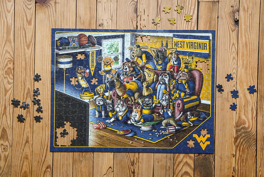 A photo of the WVU jigsaw being put together on a wood floor.